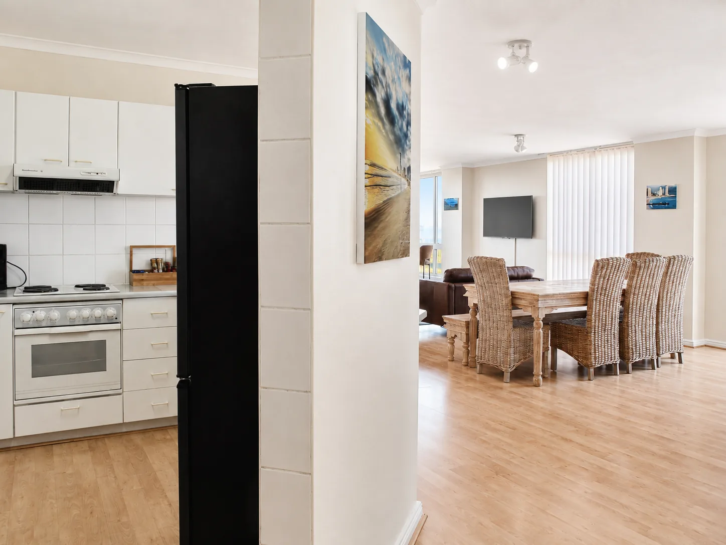 Apartment interior featuring a fitted kitchen beside an open-plan dining and living area